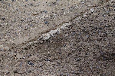 Jól látszik a régi útszerkezet - fent az egykor aszfaltnak nevezett réteg. Az új részen homogén, laza a felső réteg - a tömörítás még hátravan