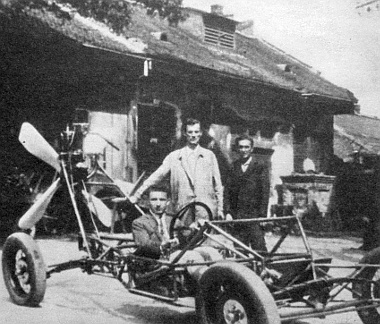 Ez a kép 1928-ban készült, a karosszéria nélküli vázszerkezet mögött Hegyi Győző és Nagy Károly, a vezetőülésben Vigh Mihály
